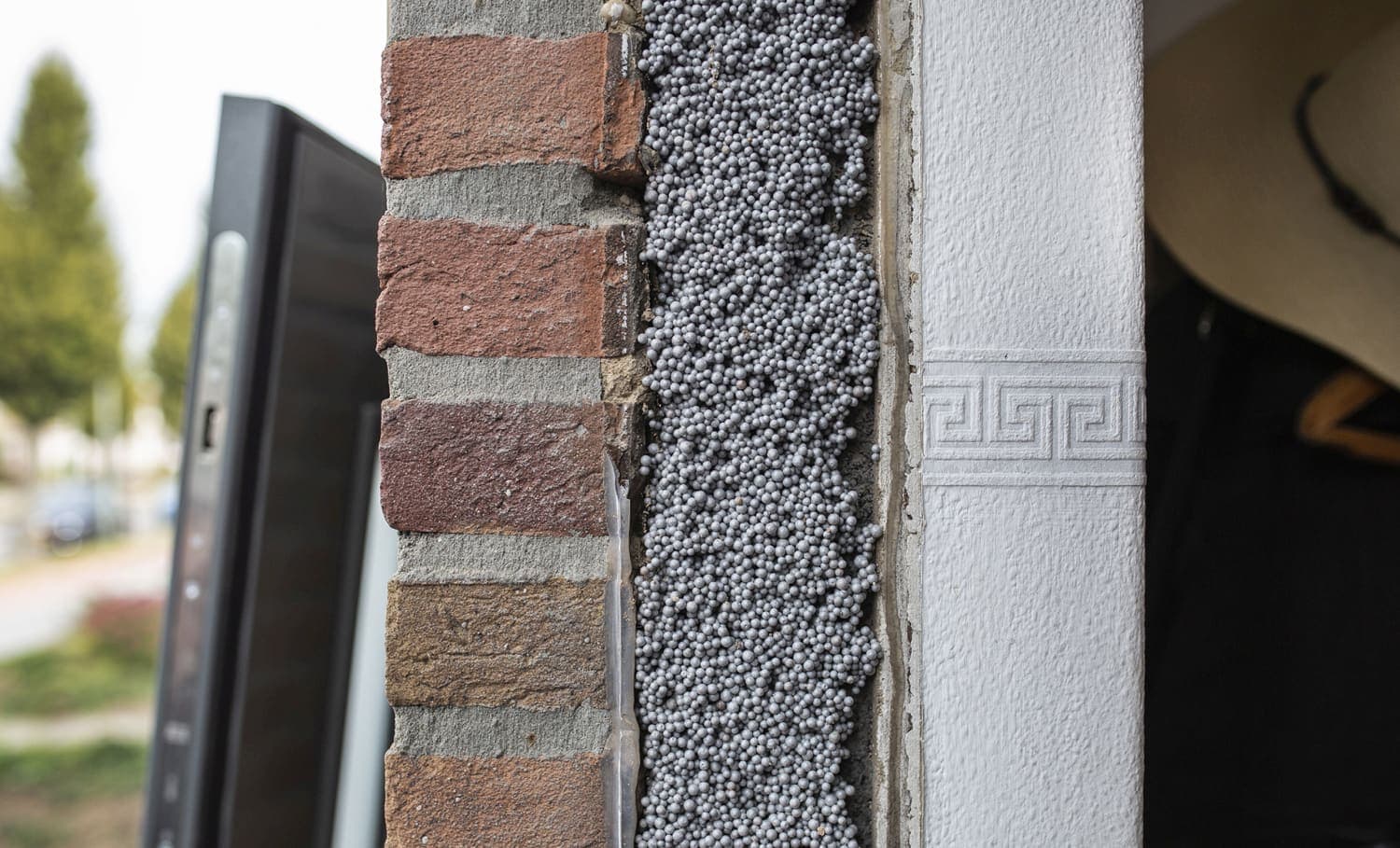 Doorsnede van een spouwmuur waarin de spouw is gevuld met isolatieparels.